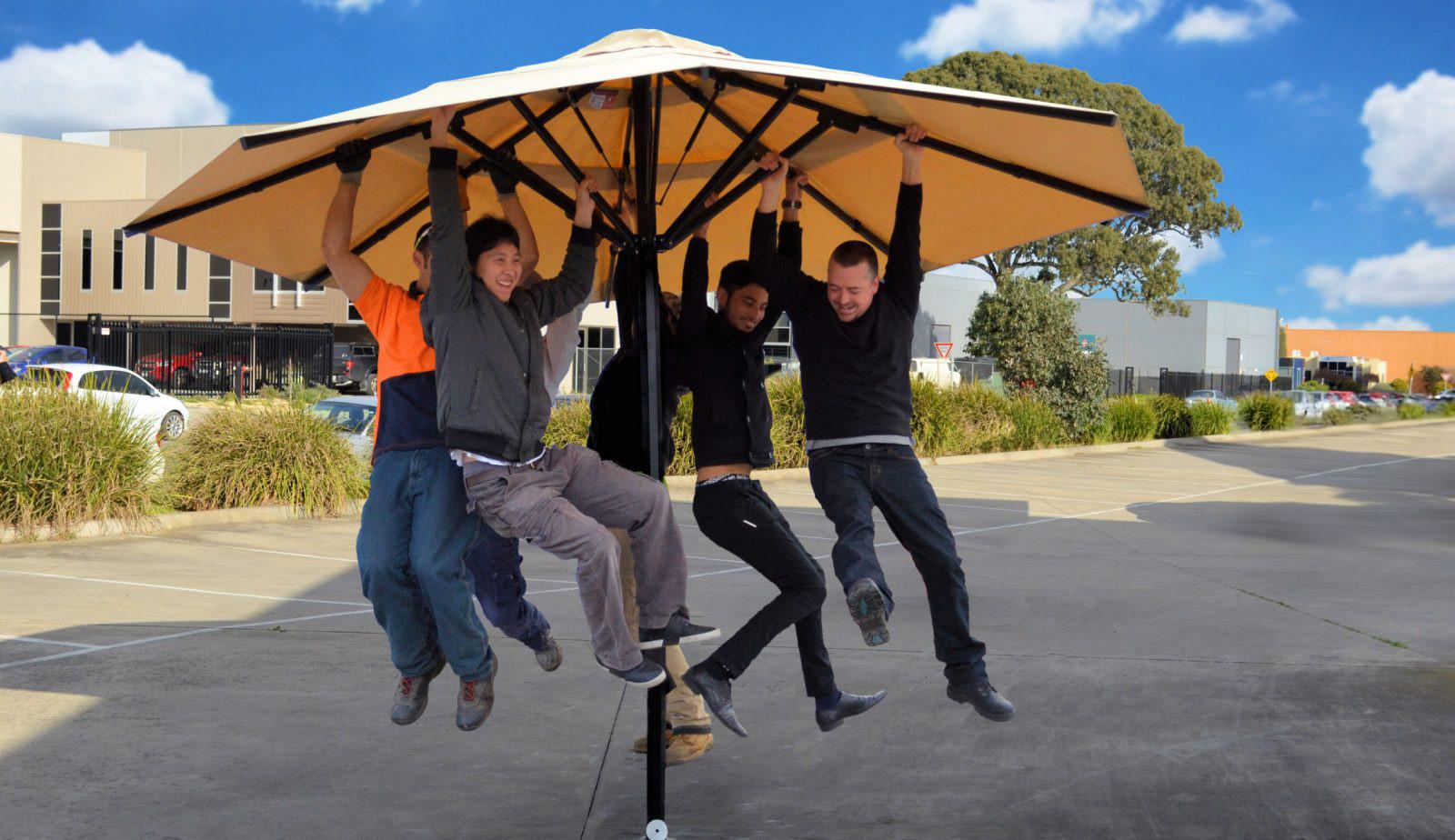 Ausbrella Worlds Strongest Umbrella with 5 men hanging off it